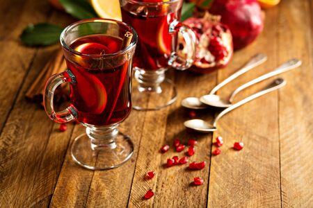 Mulled wine with pomegranate and orange in a rustic settingの写真素材