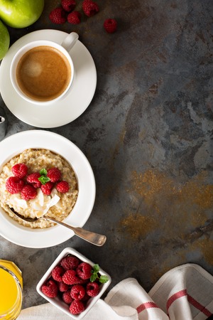 Steel cut oatmeal porridge with raspberry and coconut flakes for breakfast overhead shot whith copyspaceの写真素材