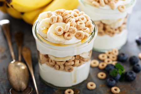 Yogurt parfait with cereal, banana and maple syrupの写真素材