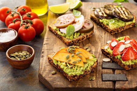 Variety of avocado toasts on a cutting boardの写真素材