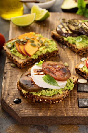 Variety of avocado toasts on a cutting boardの写真素材