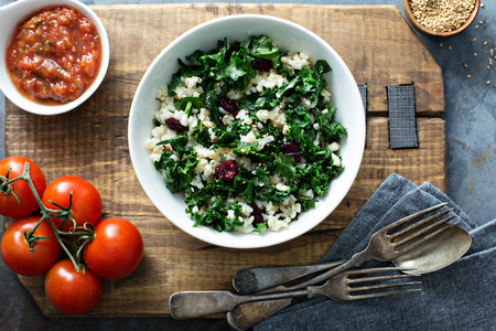 Warm kale salad with brown rice and cranberry overhead shotの写真素材