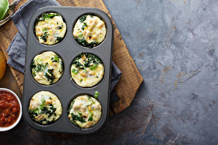High protein egg muffins with kale and ground turkey in a muffin tin overhead shot with copyspaceの写真素材