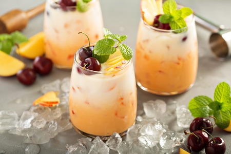 Summer refreshing drink, cherry and peach coconut milk cocktail with iceの写真素材