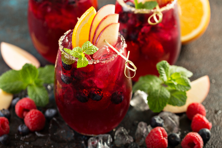 Festive summer berry and fruit sangria with apple and orangesの写真素材