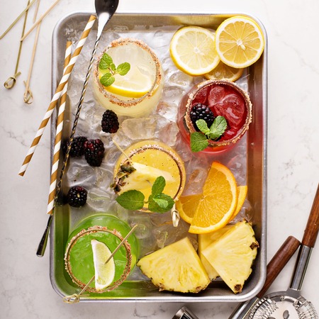 Variety of margarita cocktails with bartender tools on a tray overhead shot