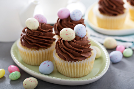 Easter vanilla cupcakes with chocolate frosting and candy eggsの写真素材