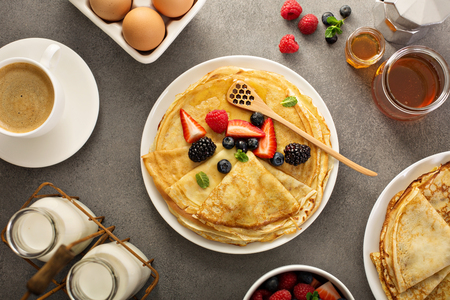 Thin crepes with berries and honeyの写真素材