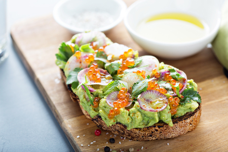 Gourmet avocado toast with caviar and radishesの写真素材