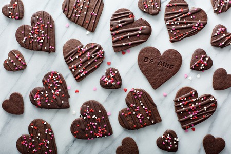 Chocolate hearts cookies for Valentines day with glaze and sprinkles overhead shotの写真素材