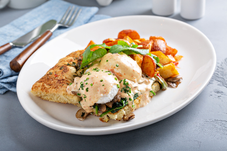 Eggs Benedict with focaccia and potatoesの写真素材