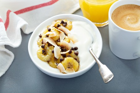 Plain yogurt with bananas, chocolate and coconutの写真素材