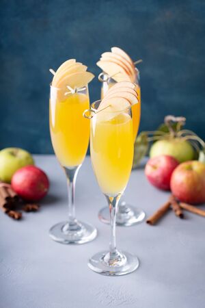 Apple mimosa cocktail in tall flute glasses, fall drinksの写真素材