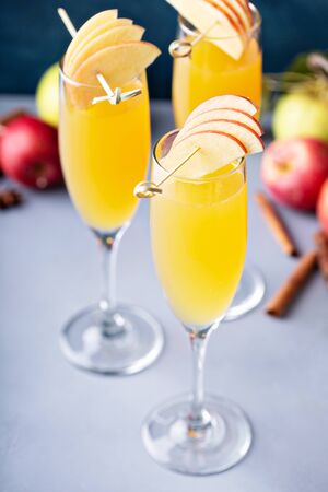 Apple mimosa cocktail in tall flute glasses, fall drinksの写真素材