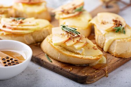 Pear and brie crostini with honey, pecan and rosemary, New Years Eve or Christmas party appetizerの写真素材