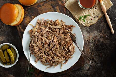 Pulled pork with forks on a plate with barbeque sauce