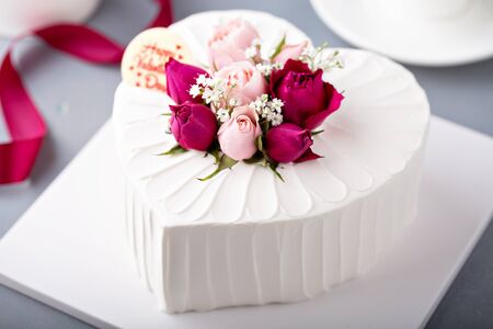 Valentines Day cake with cream topped with fresh rosesの写真素材