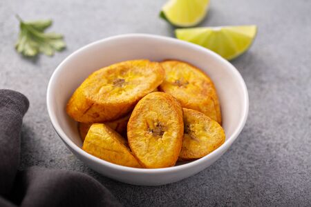 Fried plantains with fresh lime in the background, carribean cuisine