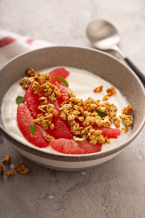 Yougurt bowl with grapefruit slices, honey and granolaの写真素材