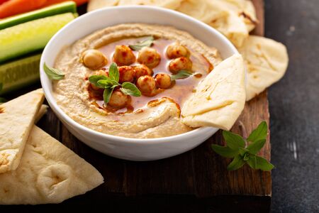 Homemade hummus served with flatbread and vegetablesの写真素材