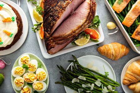 Big traditional Easter brunch with ham, quiche lorraine and carrot cakeの写真素材