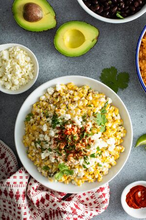 Mexican street corn dish on grey