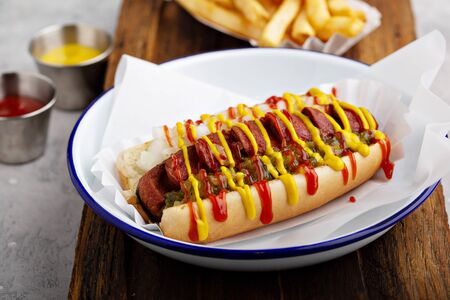 Grilled bacon wrapped hot dog with relish, ketchup and mustardの写真素材