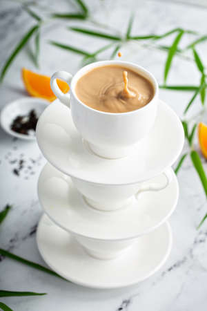 Earl grey milk tea poured in stacked cupsの写真素材