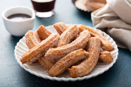 Homemade churros with cinnamon sugar on a plateの写真素材