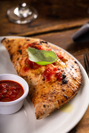 Traditional Italian cheese calzone with marinara sauce