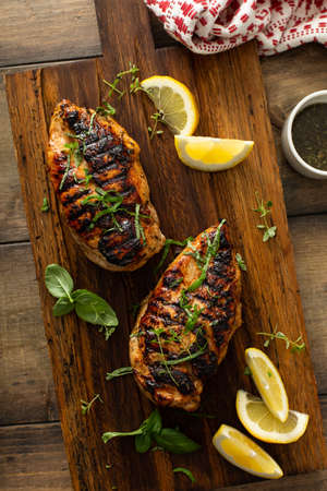 Balsamic grilled chicken breast on a boardの写真素材