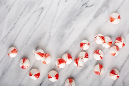 Peppermint meringues on a marble table, Christmas background