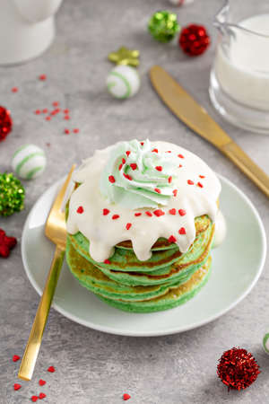 Green pancakes served with white glaze and whipped creamの写真素材