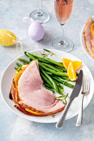 Easter baked ham served on a plate with green beansの写真素材