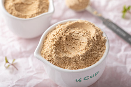 Maca powder in measuring cups and a spoon