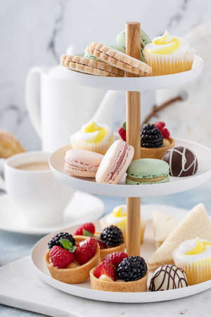 Spring or summer dessert table, three tiered tray with dessertsの写真素材