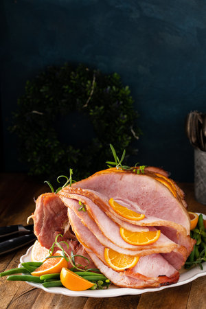 Christmas honey orange glazed ham served on a plate with green beansの写真素材