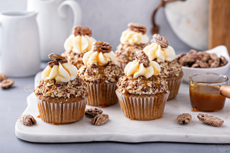 Candied pecan cupcakes with cream cheese frosting and caramelの写真素材
