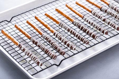 Chocolate covered pretzel rods freshly made on a cooling rackの写真素材