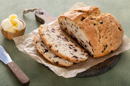 Soda bread in a cast iron pan with cranberries and pecans sliced and served with irish butter, irish recipe idea with St Patricks dayの写真素材