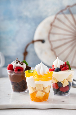 Variety of small desserts in cups, chocolate, berry and orange trifles or parfaitsの写真素材