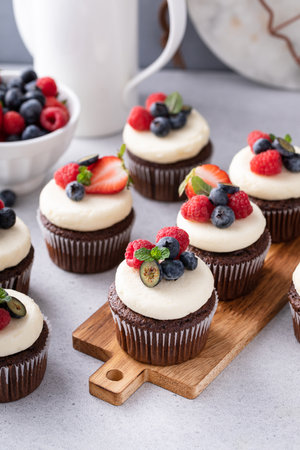 Chocolate cupcakes with cream cheese frosting and fresh summer berriesの写真素材