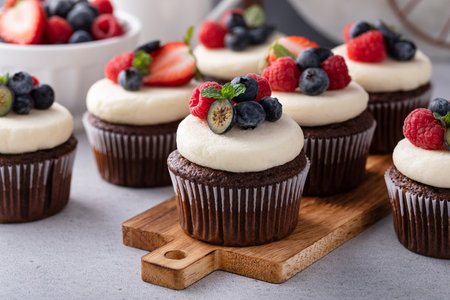 Chocolate cupcakes with cream cheese frosting and fresh berriesの写真素材