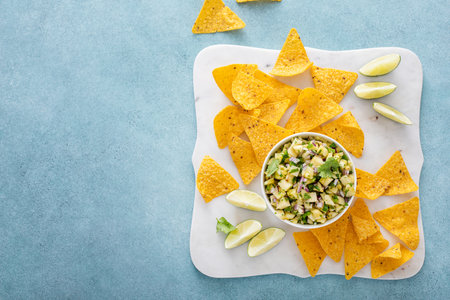 Fresh pineapple and jalapeno salsa in a bowl with tortilla chipsの写真素材