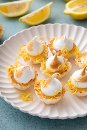 Mini lemon meringue tarts filled with lemon curd, one bite desserts ideaの写真素材