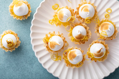 Mini lemon meringue tarts filled with lemon curd, one bite desserts ideaの写真素材