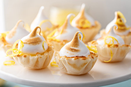Mini lemon meringue tarts filled with lemon curd, one bite desserts ideaの写真素材