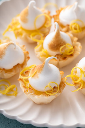 Mini lemon meringue tarts filled with lemon curd, one bite desserts ideaの写真素材