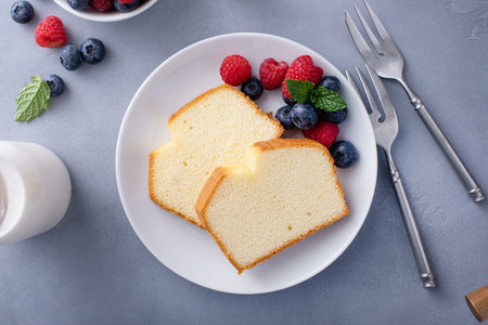 Classic pound cake sliced served with fresh raspberries and blueberriesの写真素材