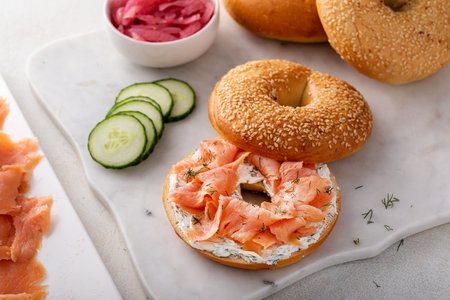 Freshly baked bagels served with dill cream cheese, salmon and cucumbersの写真素材
